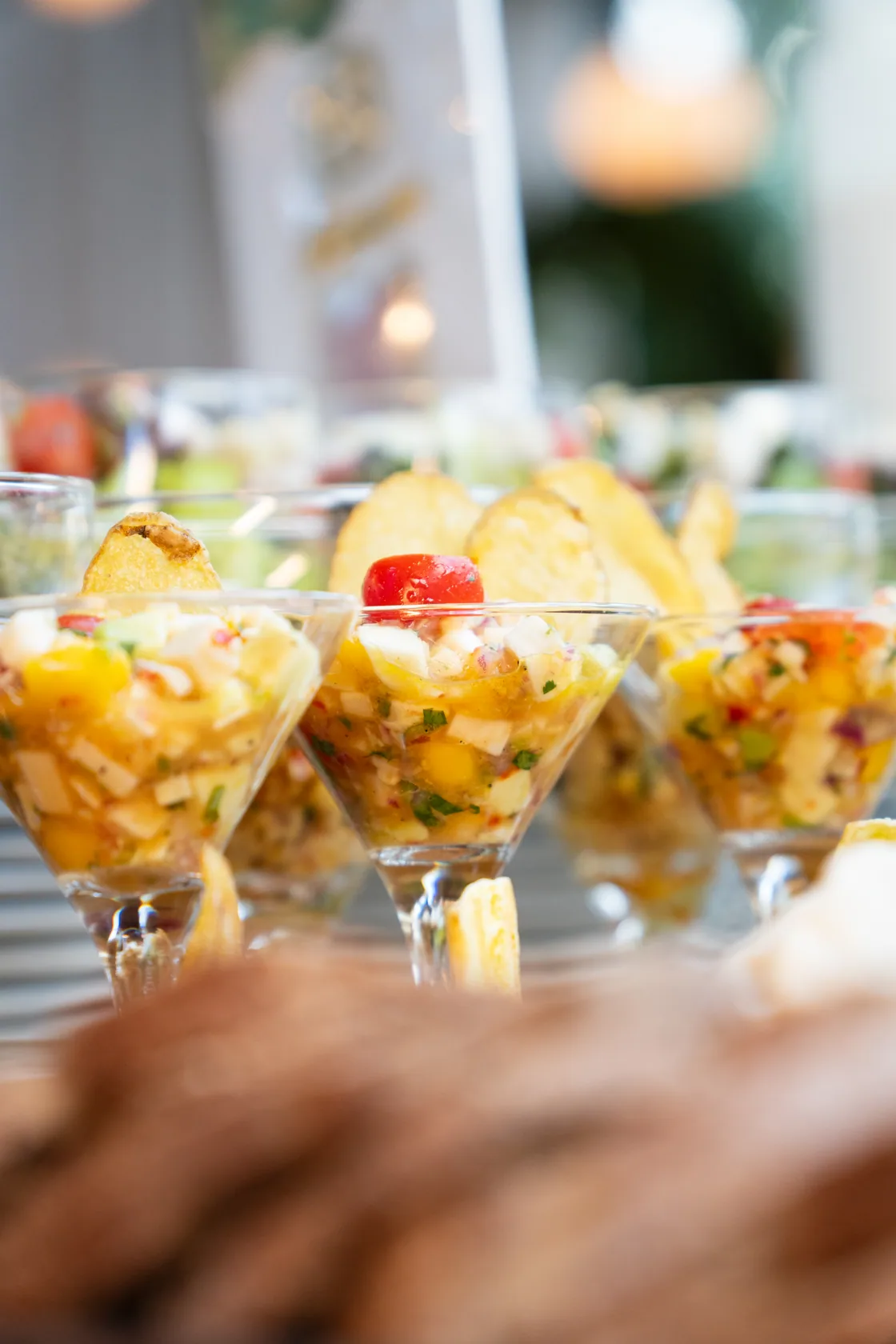 Porções individuais em taças de vidro sobre uma mesa de buffet